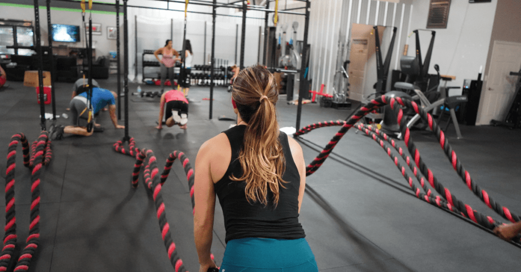 women on battle ropes in gym women on battle ropes in gym