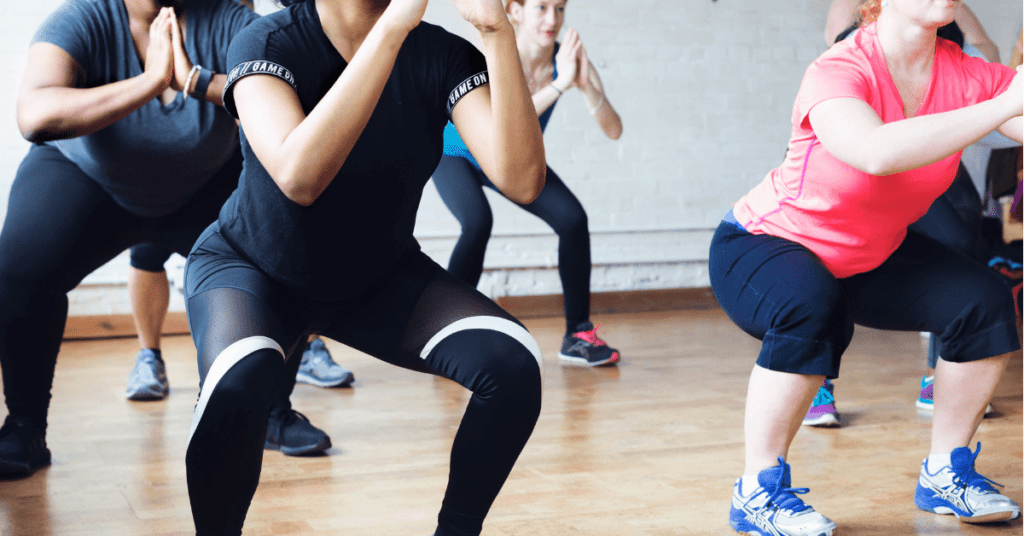 women squatting in a fitness class women squatting in a fitness class